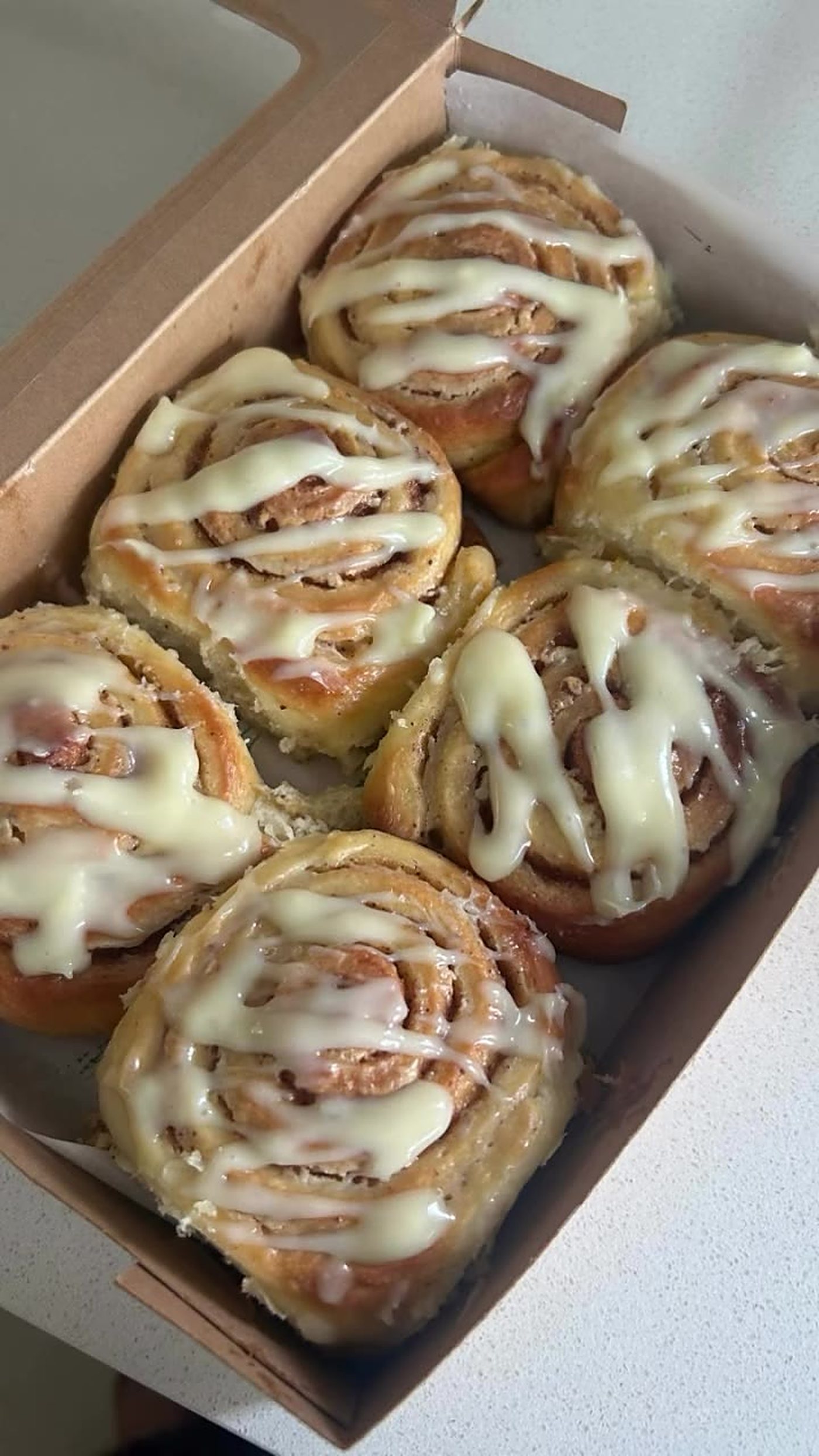 Cinnamon rolls with cream glaze in a box