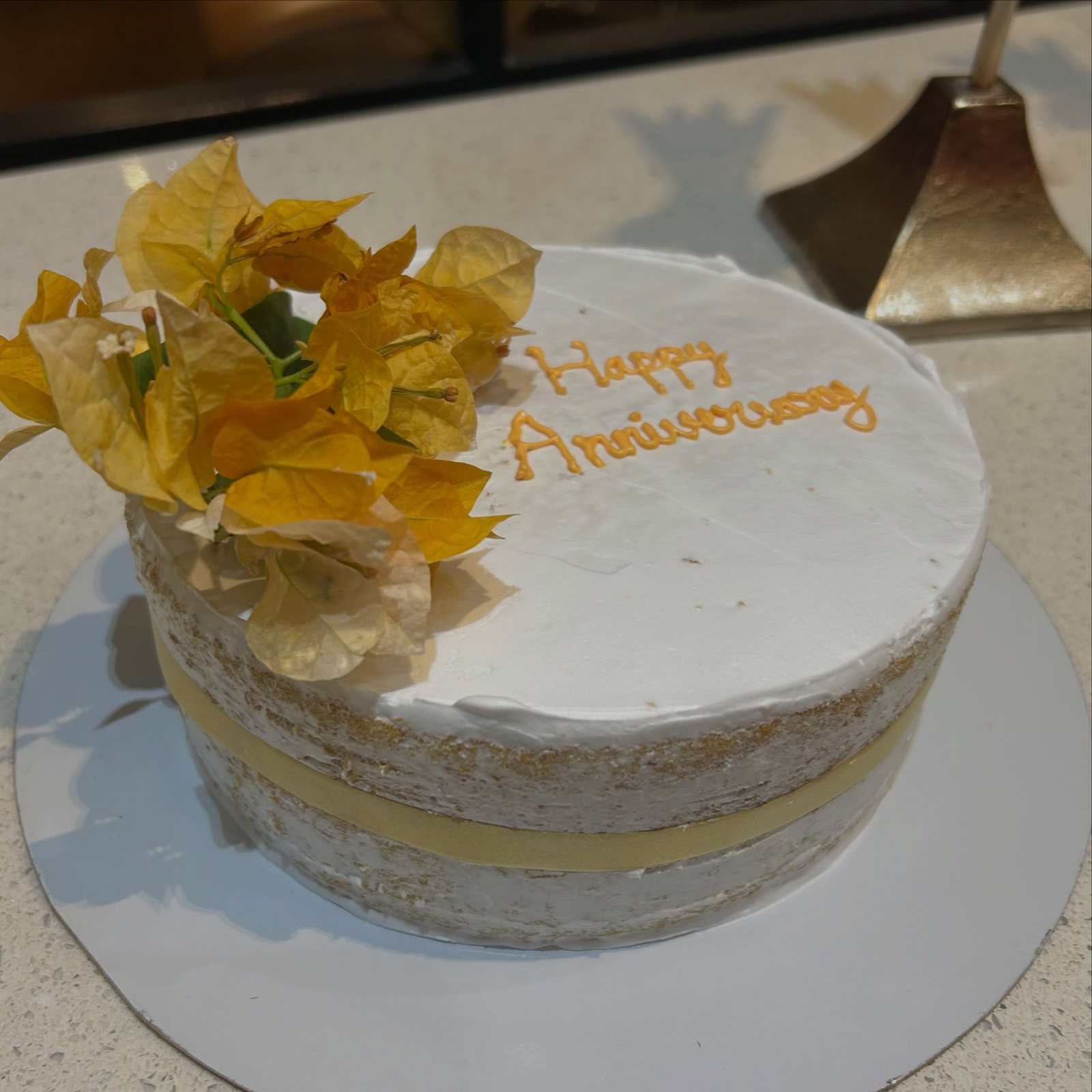 Semi-naked vanilla anniversary cake with fresh flowers